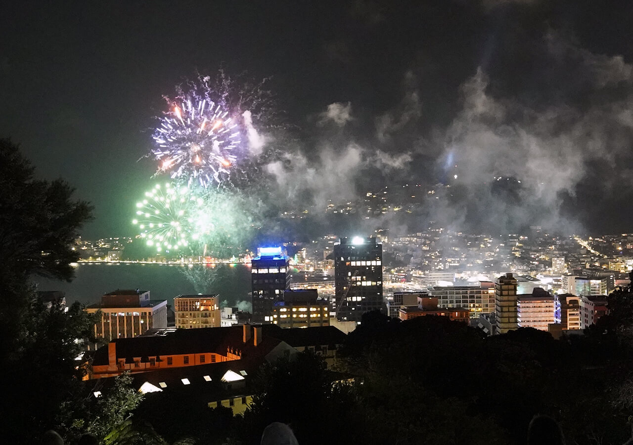 Looking down on Wellington Central, at night, as the fireworks explode over the harbour bay