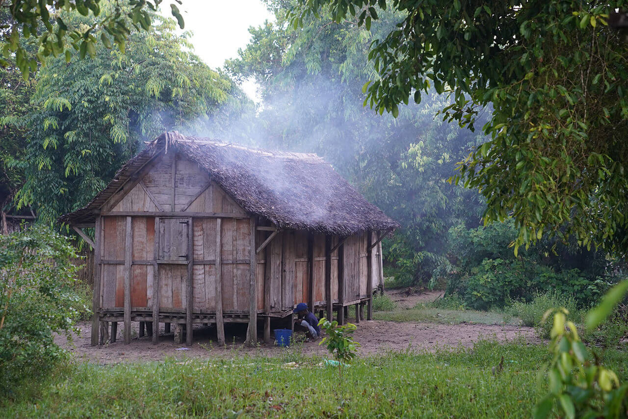 A raised cabin, made of natural materials is home to many Malagasy. This particular one has all the windows shut, but smoke is leaking out from all the gaps in the roof and walls, clearly someone is cooking breakfast inside.